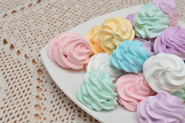Fototapeta na wymiar Close up of a plate with pastel colored meringues