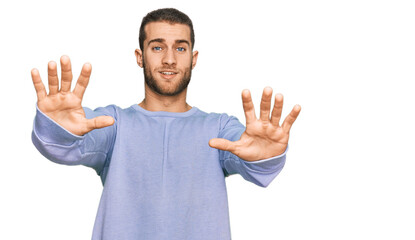 Fototapeta premium Young caucasian man wearing casual clothes afraid and terrified with fear expression stop gesture with hands, shouting in shock. panic concept.