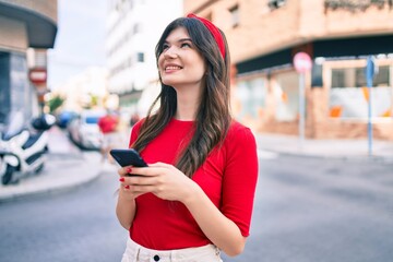 Young caucasian woman smiling happy using smartphone walking at the city.