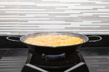 Fideua cooking in a paella