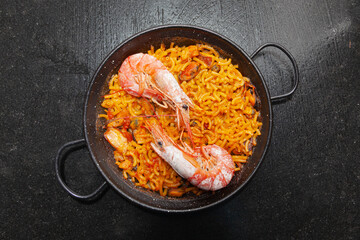 Fideua cooked in a paella with two prawns