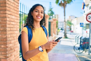 Young african american student girl using smartphone at university campus.