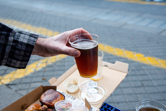 Eating Out During The Pandemic. Man Holding A Cold Glass Of Beer Outdoors. High Quality Photo