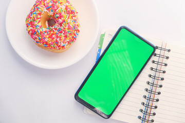 top view of smart phone and notepad on table 