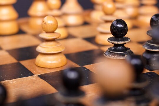 Chess Pawns On an old wooden chessboard close up