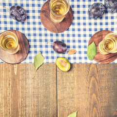 Plums and shot glasses with rakia on the table