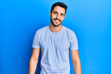 Fototapeta premium Young hispanic man wearing casual clothes with a happy and cool smile on face. lucky person.