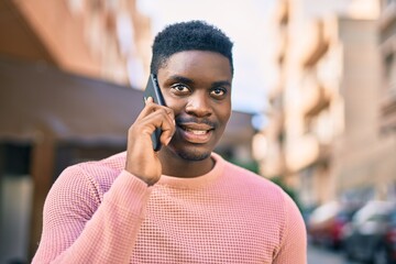 Young african american man smiling happy talking on the smartphone at the city.
