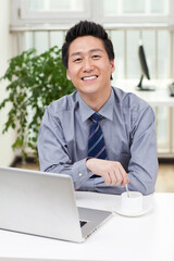 Close-up of a businessman using a laptop in an office