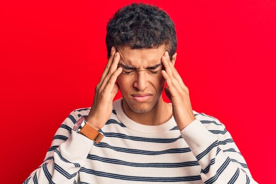 Young african amercian man wearing casual clothes suffering from headache desperate and stressed because pain and migraine. hands on head.