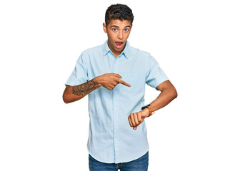 Young handsome african american man wearing casual clothes in hurry pointing to watch time,...