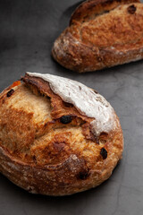 Sourdough bread with mixed fruits and nuts on dark cement background.