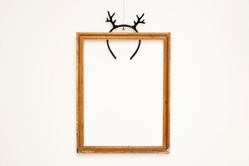 decorative golden frame with black deer horns on white wall. place for text