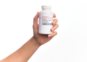 Hand of caucasian young man holding bottle of  pills over isolated white background