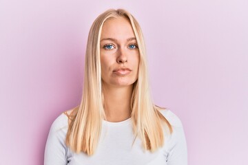 Young blonde girl wearing casual clothes relaxed with serious expression on face. simple and natural looking at the camera.