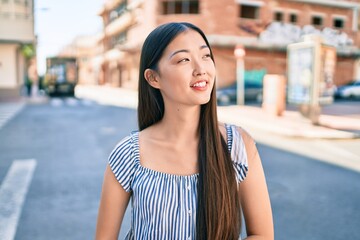 Young chinese woman smiling happy walking at street of city.