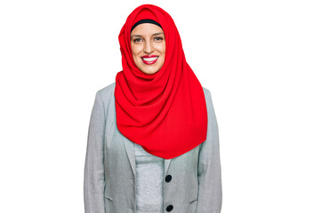 Beautiful hispanic woman wearing traditional islamic hijab scarf looking positive and happy standing and smiling with a confident smile showing teeth