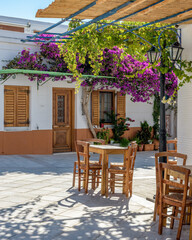 Traditional Cycladitic alley with traditional houses and a blooming bougainvillea flowers in lefkes Paros island, Greece