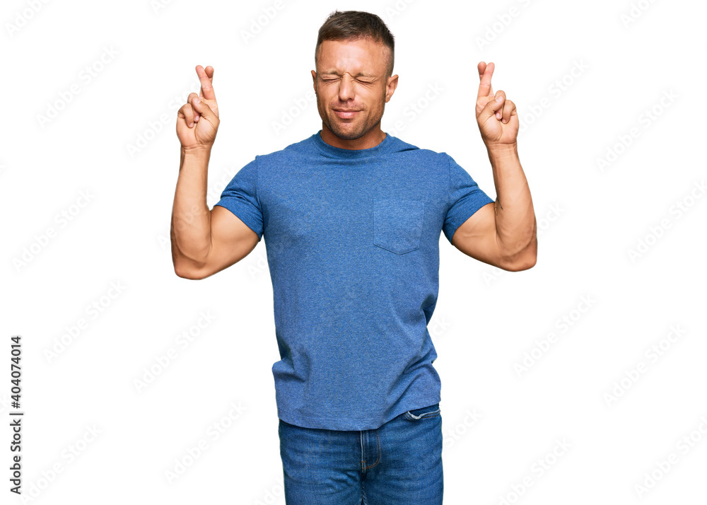 Poster handsome muscle man wearing casual clothes gesturing finger crossed smiling with hope and eyes close