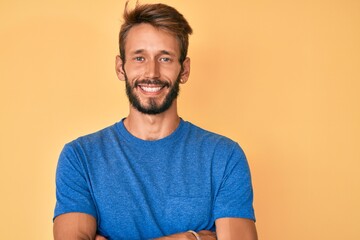 Handsome caucasian man with beard wearing casual clothes happy face smiling with crossed arms looking at the camera. positive person.