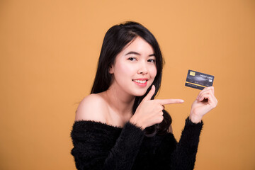 Young smiling Asian woman presenting credit card in hand showing trust and confidence for making payment,Reliable financial company