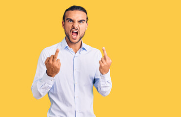 Young handsome man wearing business clothes showing middle finger doing fuck you bad expression,...