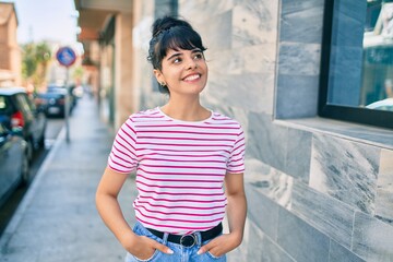 Young hispanic girl smiling happy walking at the city.