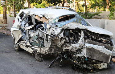 Closeup of front side of damaged white  sedan car from road traffic accident. 