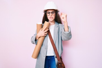 Cute hispanic child girl wearing architect hardhat holding blueprints annoyed and frustrated shouting with anger, yelling crazy with anger and hand raised