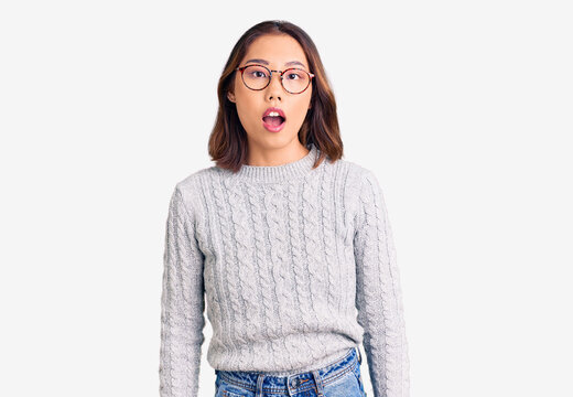 Young beautiful chinese girl wearing casual clothes afraid and shocked with surprise and amazed expression, fear and excited face.