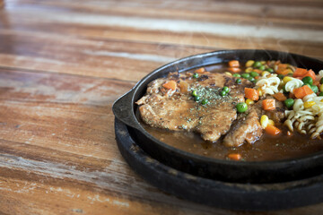 pork stake serve on hot pan with gravy suace with green bean