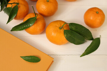 mandarin with green leaves on wooden background, orange color