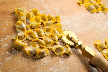Ravioli del plin, typical pasta from Langhe, Piedmont, Italy - agnolotti with wheel knife on wooden...