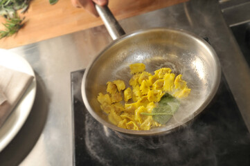 Ravioli del plin, typical pasta of the Langhe, Piedmont, Italy - agnolotti creamed in a pan with...
