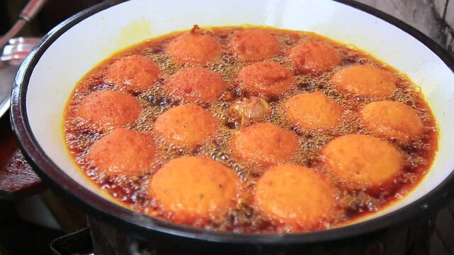salvador, bahia, brazil - january 8, 2021: acaraje during frying in a pan with palm oil, in downtown Salvador.