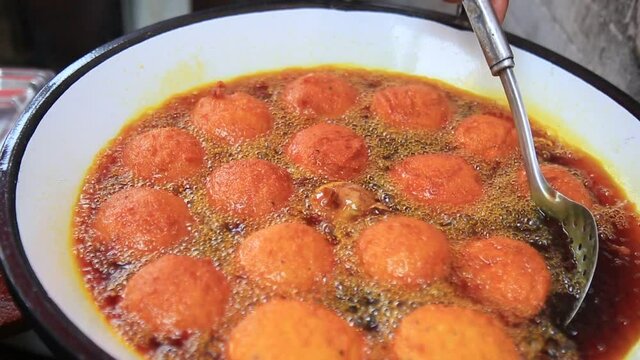 salvador, bahia, brazil - january 8, 2021: acaraje during frying in a pan with palm oil, in downtown Salvador.