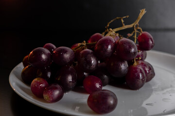 Juicy red grapes on a plate.