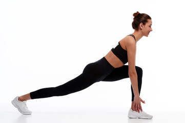 Slim and strong caucasian woman doing stretching exercise before physical training, white isolated background