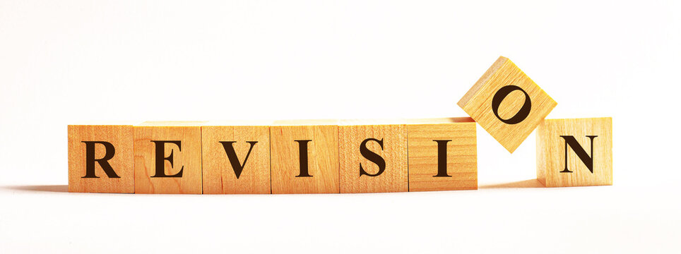 On a light background, wooden cubes with the text REVISION