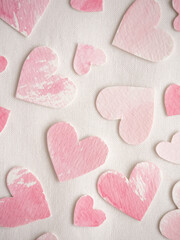 Paper hearts painted in pink watercolor on a white background