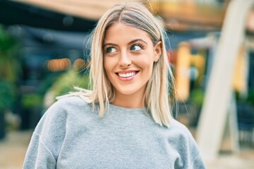 Fototapeta premium Young blonde girl smiling happy standing at the city.