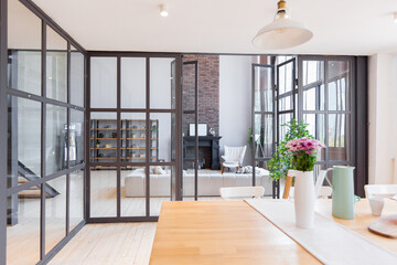 trendy modern design two-level apartment with large high windows. The stylish living room and kitchen in bright colors are undressed by a glass partition. bedroom on the second floor.