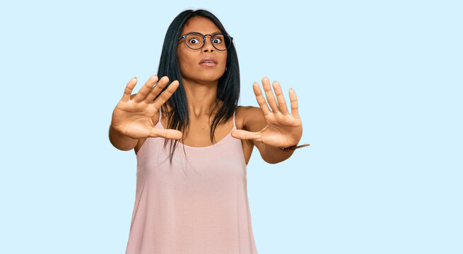 Young african american woman wearing casual clothes and glasses doing stop gesture with hands palms, angry and frustration expression