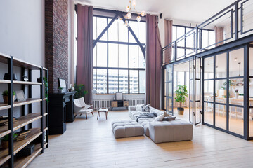 trendy modern design two-level apartment with large high windows. The stylish living room and kitchen in bright colors are undressed by a glass partition. bedroom on the second floor.