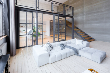 trendy modern design two-level apartment with large high windows. The stylish living room and...