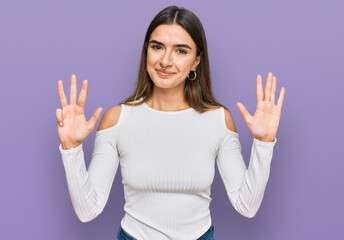 Young hispanic woman wearing casual clothes showing and pointing up with fingers number nine while smiling confident and happy.