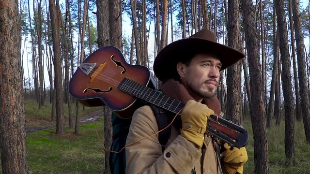 A man with a guitar in the forest. Travel concept. Slow motion