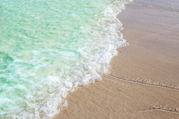 Close up of Soft beautiful ocean wave on a sandy beach for texture Background with copy space.