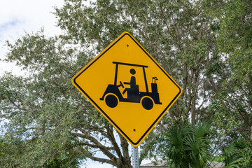 Golf cart crossing sign with foliage in background