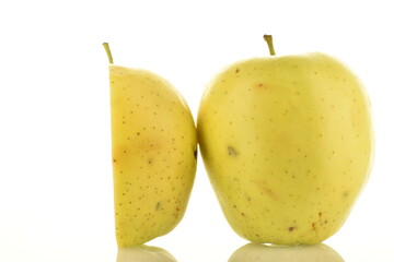 One half and one whole juicy yellow apples, close-up, on a white background.